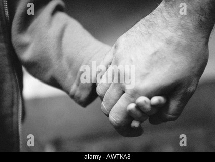 Erwachsenen Hand Holding Kind die hand, Nahaufnahme, b&w Stockfoto