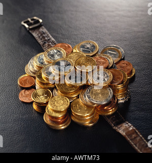 Haufen von verschiedenen Euro-Münzen auf Uhrenarmband Stockfoto