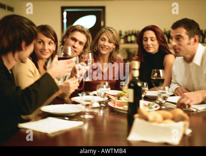 Gruppe junger Leute sitzen am Tisch, beim Abendessen zusammen Stockfoto
