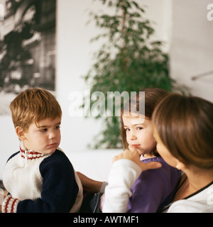 Kinder sitzen mit Mutter Stockfoto