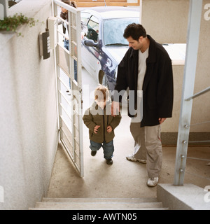 Vater kommen in Tür mit Sohn, Ganzkörperansicht, erhöhte Ansicht Stockfoto