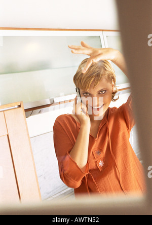 Teengirl mit Handy und Fixierung Haar im Spiegel Stockfoto