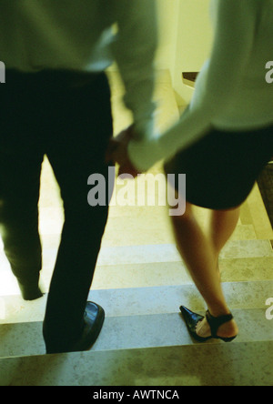 Paar Treppen hinunter, Hand in Hand, Rückansicht Stockfoto