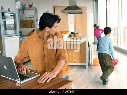 Vater, Rückblick auf die Kinder spielen mit Bällen im Haus. Stockfoto