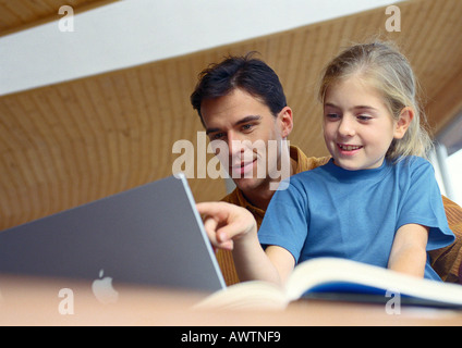 Vater und Tochter gemeinsam auf Computer. Stockfoto