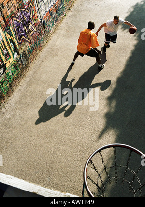 Mann dribbling Basketball, Gegner blockiert in städtischen Spielplatz Stockfoto