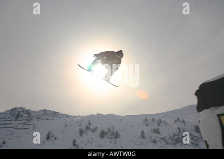 Springen Snowboarder auf Snowboard tricksen, Österreichische Alpen, Tirol, Tirol, Österreich Stockfoto