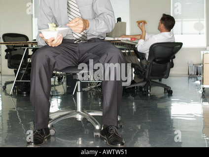 Zwei Geschäftsleute in Büro, Essen, Essen zum mitnehmen Stockfoto