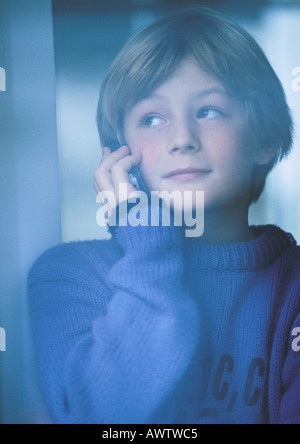 Junge am Telefon, Blick aus Fenster, Porträt Stockfoto