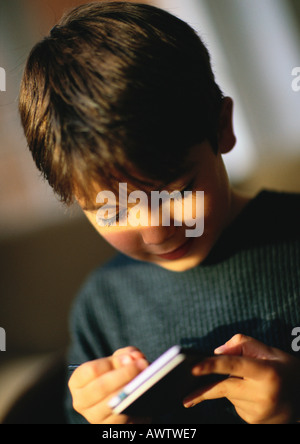 Kleiner Junge spielt mit Hand statt persönlicher Assistent, Nahaufnahme Stockfoto