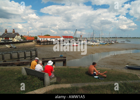 Heybridge Basin Maldon Essex Menschen entspannend neben dem Fluss Blackwater mit Anlegestellen über Essex England Großbritannien Stockfoto