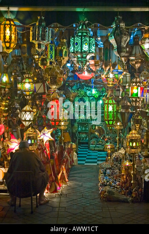 Vertikale Nahaufnahme von einem Ladenbesitzer seine bunten Läden, traditionelle marokkanische Lampen und Laternen in der Nacht draußen. Stockfoto