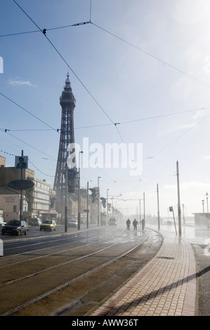 Hilfsgerät zu Fuß entlang der Strandpromenade in Blackpool tram Tracks auf einer nassen und windigen Tag im Winter Stockfoto