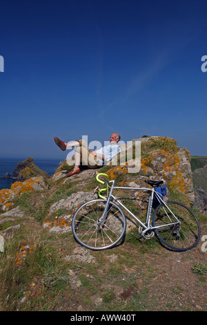 Ein Radfahrer auf dem Küstenpfad SW Halbinsel entspannt über Kynance Cove Cornwall UK Stockfoto