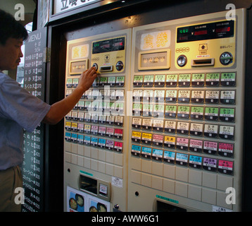 Mann kaufen Softdrink aus Straße Automaten, Shinjuku-Tokio Stockfoto