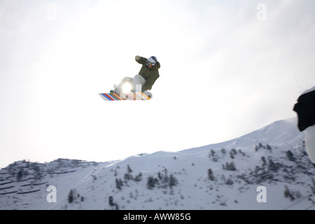 Springen Snowboarder auf Snowboard tricksen, Österreichische Alpen, Tirol, Tirol, Österreich Stockfoto