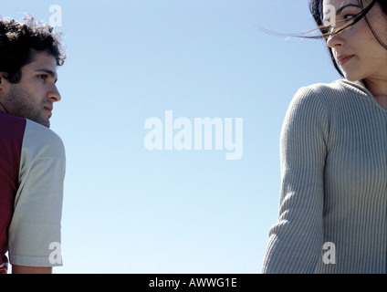 Junger Mann und junge Frau sahen einander mit Himmel im Hintergrund Stockfoto