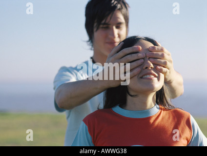 Mann, übergibt die Augen Frau Stockfoto