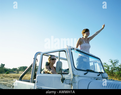 Zwei Frauen in 4 x 4 Fahrzeug, aufstehen, winken Stockfoto