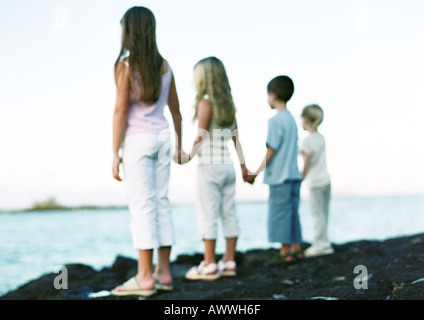 Kinder stehen, Hand in Hand, Blick auf das Meer Stockfoto