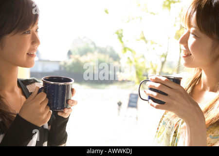 Zwei junge Frauen mit Tassen in Tür Stockfoto