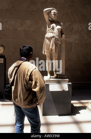 USA New York City das Metropolitan Museum of Art. Man studiert eine griechische Statue im griechischen und römischen Kunstflügel des Museums. Stockfoto