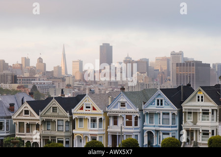 Painted Ladies viktorianischen Häuser auf Postkarte Zeile am Alamo Square mit der Skyline in der Ferne, San Francisco, Kalifornien, USA Stockfoto