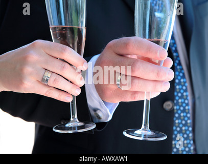 Frisch verheiratete Hände Angeberei Trauringe und Sektgläser Stockfoto