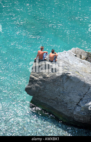 Luftaufnahme von zwei jungen sitzen auf Felsen in tiefblauen Ozean suchen Stockfoto