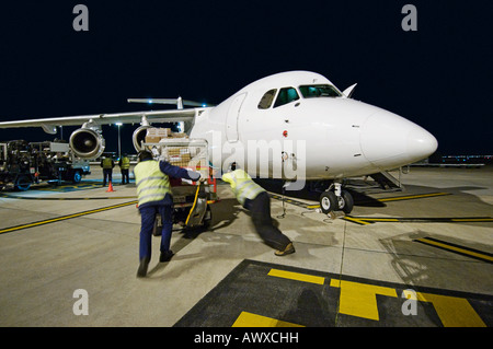 Luftfracht, die Verladung auf BAE-146 in der Nacht. Stockfoto