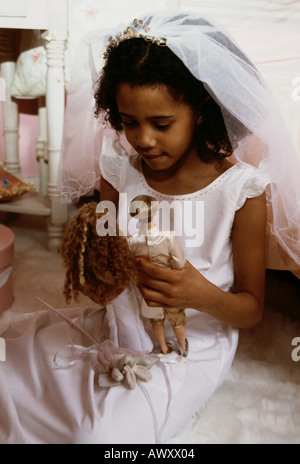 Kleine schwarze Mädchen Hochzeitsspiele mit ihrer Barbie Puppen zu spielen. Stockfoto