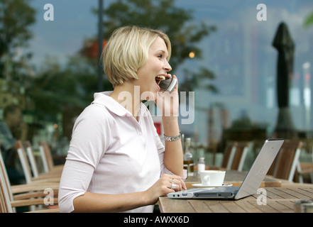 junge Frau mit Laptop im coffeeshop Stockfoto