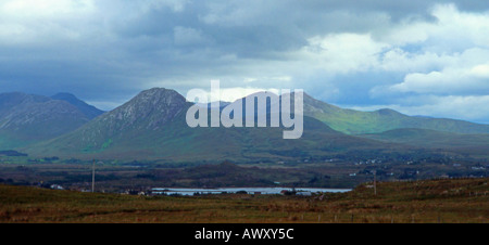 Sonnenlicht und Schatten über die Twelve Bens (Pins), Connemara, Irland von Cleggan Moyard Straße anzeigen Süd. Stockfoto