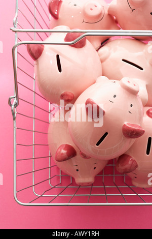 Warenkorb mit Sparschweine auf rosa Hintergrund, Ansicht von oben Stockfoto