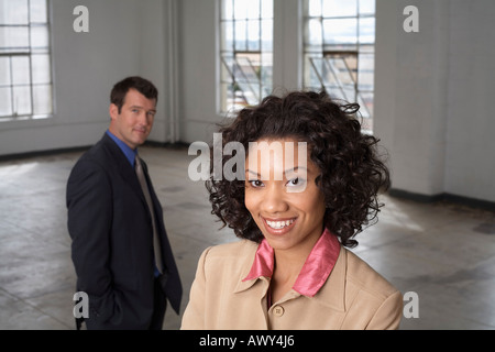 Porträt der Geschäftsfrau mit Geschäftsmann im Hintergrund Stockfoto