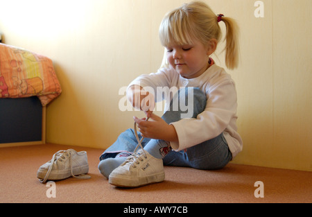 Kleine Mädchen ihre Schuhe anziehen Stockfoto