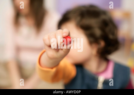Mädchen einen kleinen roten Block in die Kamera halten Stockfoto