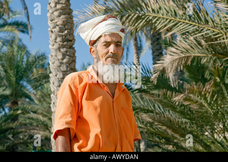 Dorf von Nakhl, Oman: Porträt eines bärtigen Mannes trägt einen weißen Turban und orange Sprunganzug Stockfoto