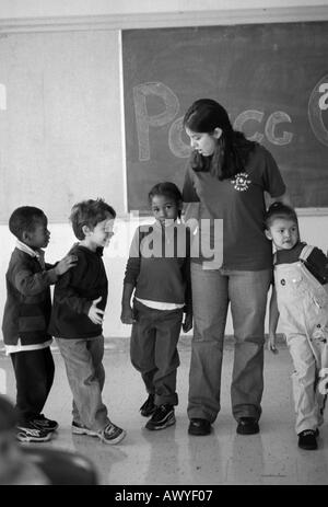 Peacegame s Freiwilligen im ersten Grade Klassenzimmer mit tudenten Stockfoto