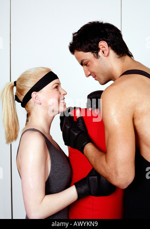 Junger Mann und Frau flirten in einer Fitness-Klasse Stockfoto