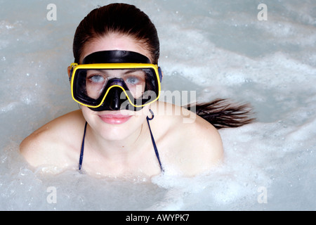 Eine Frau mit Maske im Whirlpool in einem spa Stockfoto
