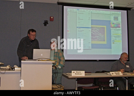 Weibliche Moderatorin hält Vortrag zu Geschäftstreffen und nutzt digitalen Projektion in ihrer Präsentation Stockfoto