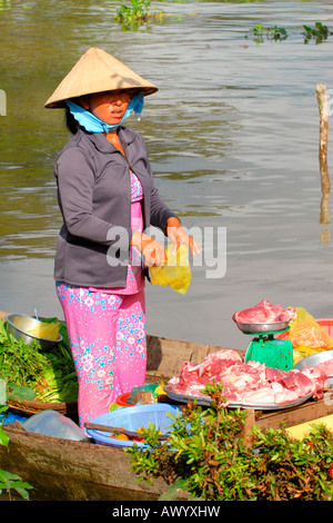 Asien Fernost Vietnam , Mekong Delta , ziemlich junge native Mädchen in nicht bai Tho & Nationalkleidung Verkauf Fleisch von lokalen Metzgern Bootsgeschäft Stockfoto