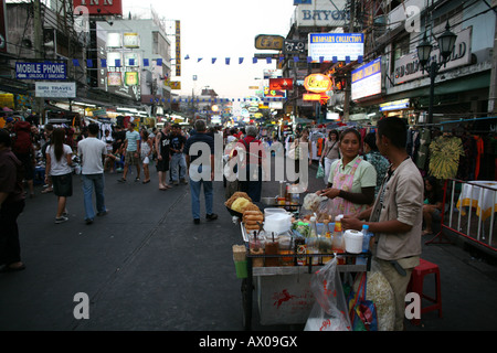 Anbieter verkaufen, Nudeln und andere Köstlichkeiten aus einem Wagen auf den Straßen der Kao San Road in Bangkok Stockfoto