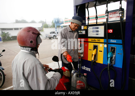 Ein Moped Fahrer wartet während er Benzin bekommt Stockfoto