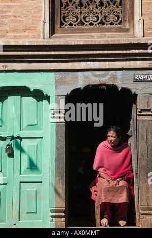 Nepal, Bhaktapur, lokale Frau sitzt in Tür Stockfoto