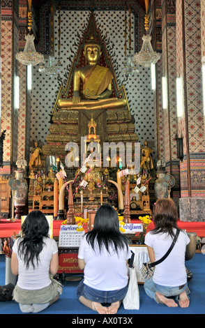 Frauen beten vor einer Buddhastatue, Wat Arun (Tempel der Morgenröte), Bangkok, Thailand, Südostasien Stockfoto