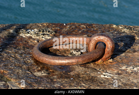 Metall-Ring an der Hafenmauer in Mousehole, Süd Cornwall, UK. Stockfoto