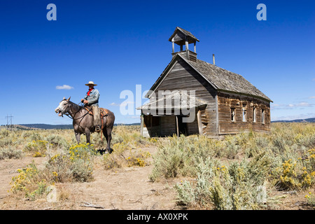 Cowboy auf Pferd im alten Schulhaus, Wildwest, Oregon, USA Stockfoto