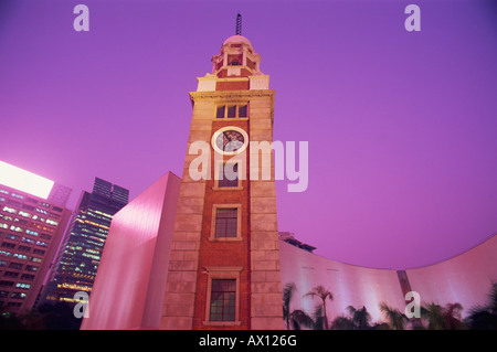 China, Hong Kong, Tsim Sha Tsui, Kowloon Canton Railway Station Uhrturm in der Abenddämmerung Stockfoto